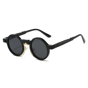 Detail of retro round steampunk sunglasses with black frames and gold metal bridge accents