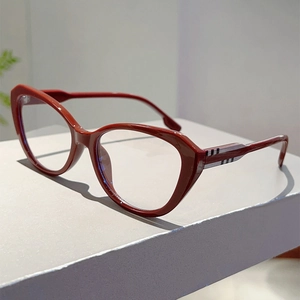 Detail van een rode cat-eye bril met klassiek gestreept patroon op de pootjes