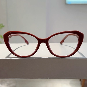 Detail van rood cat-eye brilmontuur met glanzende afwerking op een witte ondergrond
