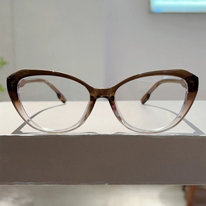 Detailopname van cat-eye brilmontuur met bruin verloop op wit platform