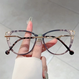 Detail of cat-eye glasses frame with purple leopard print and gold metal accents