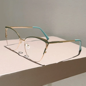 Gros plan sur les lunettes œil-de-chat en métal doré avec des accents vert menthe