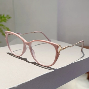 Detail of pink cat-eye frame with elegant gold metal temples and curved temple tips