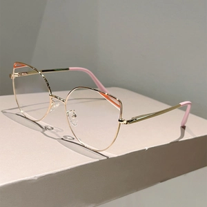 Detailed side view of golden cat-eye frames with orange accents and pink temple tips