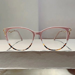 Close-up of cat-eye glasses frame with pink and tortoiseshell finish and gold wave temples
