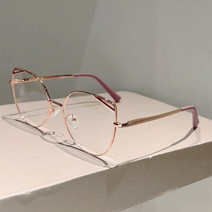 Detail of rose gold cat-eye glasses frames with hollow temples on an elegant display stand