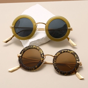 Detailed close-up of retro round sunglasses with gold metal bridge and leopard frames