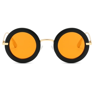 Detail view of round retro sunglasses with black frames, orange lenses and gold temples