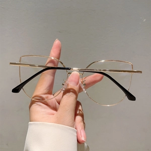 Detail of gold metal cat-eye eyeglass frame with slim temples and clear nose pads