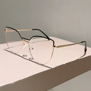 Detailed view of cat-eye metal glasses frame with gold finish and black upper accents