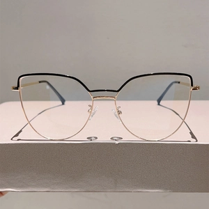 Detail of rose gold cat-eye metal glasses frame with black accents and silicone nose pads