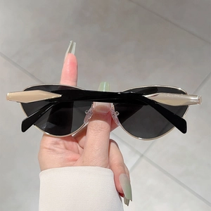 Détail de lunettes de soleil œil-de-chat tendance avec verres noirs et branches dorées