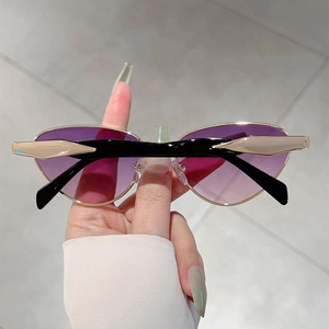 Détail des verres dégradés violets et des branches géométriques noir et or des lunettes