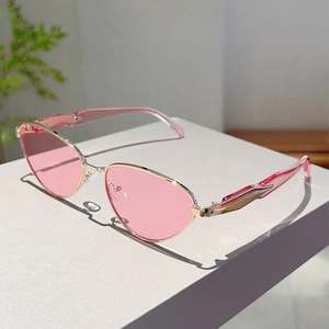 Détail de lunettes de soleil œil-de-chat roses avec monture dorée et branches roses