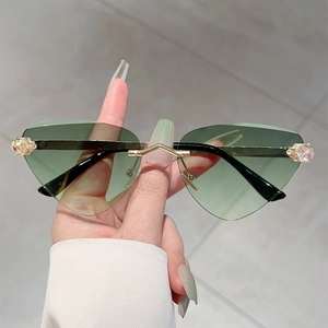 Détail de lunettes de soleil sans monture à dégradé vert avec cristaux et branches dorées
