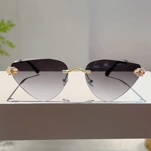 Détails de lunettes de soleil œil de chat sans monture avec pont doré et verres dégradés