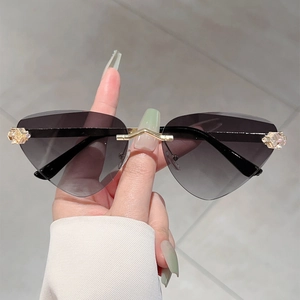 Lunettes de soleil œil de chat sans monture avec verres dégradés gris et détails dorés chic