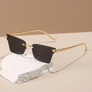 Détail de lunettes de soleil sans monture avec branches dorées et décor de tête de léopard