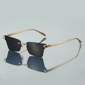 Détail de lunettes de soleil sans monture avec emblème tête de léopard doré sur la branche
