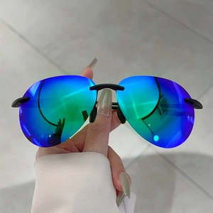 Détail de lunettes de soleil sans monture avec verres polarisés dégradés bleu-vert