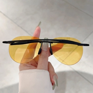 Détail de lunettes de soleil de conduite sans monture avec verres jaunes et branches en TR90