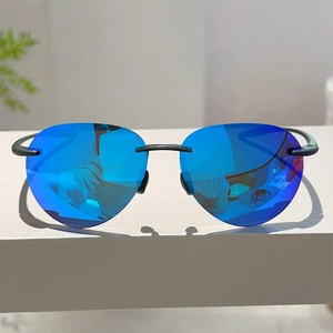 Détail de lunettes de soleil sans monture avec verres miroir bleu-violet et branches en métal