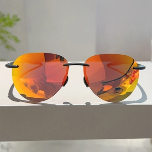 Détail de lunettes de soleil sans monture avec verres miroirs dégradés orange et rouge