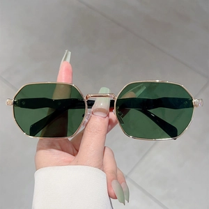 Detail shot of vintage octagonal sunglasses with green lenses and slim gold metal frame