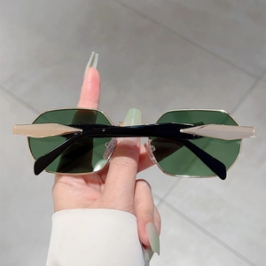 Close-up of golden polygonal metal sunglasses frame with dark green lenses and black temples