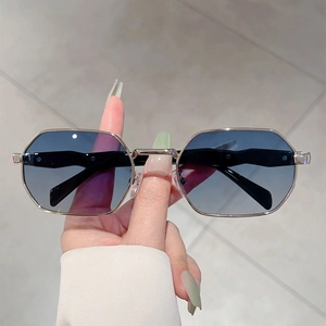Retro octagonal metal sunglasses with gradient blue lenses shown in hand for lifestyle use