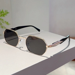 Close-up of octagonal gold metal frame sunglasses with decorative geometric temple details