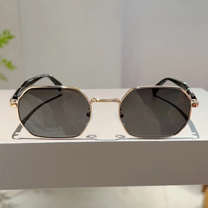 Detail of vintage geometric sunglasses with gold metal frame and dark hexagonal lenses