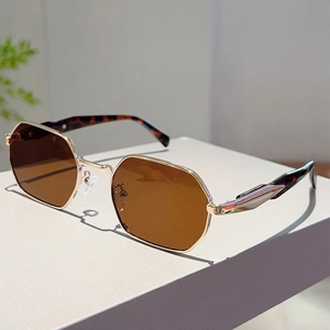 Detail of octagonal gold metal frame sunglasses with amber lenses and tortoiseshell temples