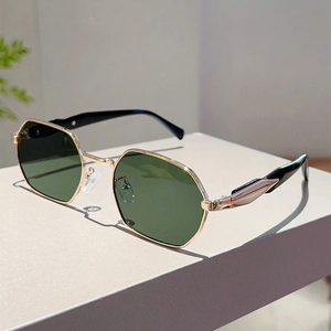 Detail of vintage hexagonal sunglasses with gold metal frame and dark green lenses