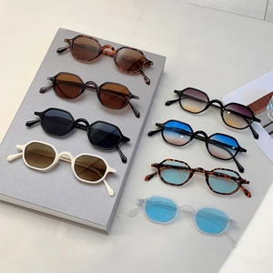 Retro tortoiseshell and solid color hexagonal sunglasses set on minimalist display
