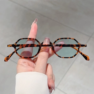 Detail of retro tortoiseshell round frame sunglasses with light blue lenses held by hand
