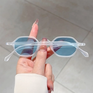 Detail of frosted white frame sunglasses with light blue lenses in a handheld view