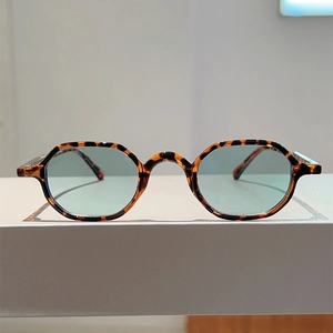 Close-up of retro tortoise shell round frames with light green lenses and vintage texture