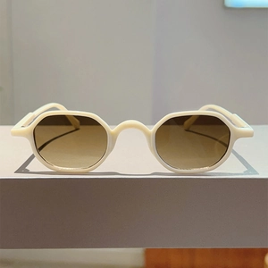 Detail view of irregular cream frames with brown gradient lenses for trendy sunglasses