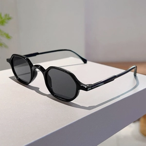 Detail view of black retro round-frame sunglasses on a modern geometric display