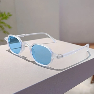 Detailed view of sunglasses with blue lenses and translucent white polygonal frames