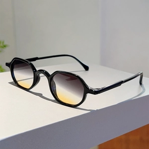 Detail of vintage black polygonal frame sunglasses with amber gradient lenses