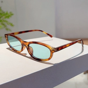 Macro detail of oval tortoiseshell sunglasses frame with stylish mint green lenses