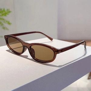 Close-up of translucent brown oval frame sunglasses on a white display block