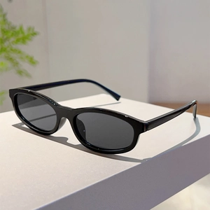 Side view of sleek black oval sunglasses with glossy frames on a minimal display