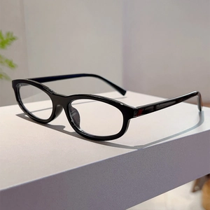 Detail view of black oval eyewear frame on a minimalist geometric white stand