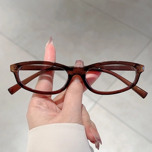 Retro dark brown oval sunglasses with slim frame for women in a minimalist street style