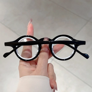 Détail d'une monture de lunettes ronde bicolore en acétate noir et blanc poli