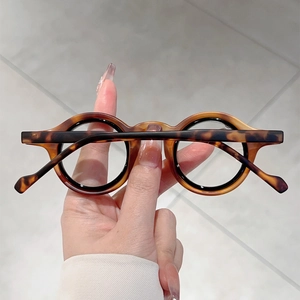 Gros plan sur des montures de lunettes rondes écaillées avec texture ambrée vintage