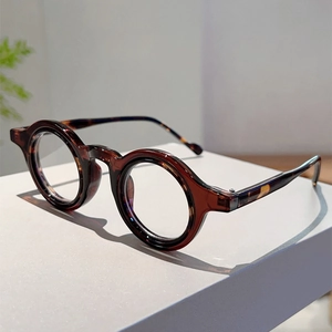 Détail de lunettes rondes rétro en écaille avec monture épaisse et texture en acétate premium